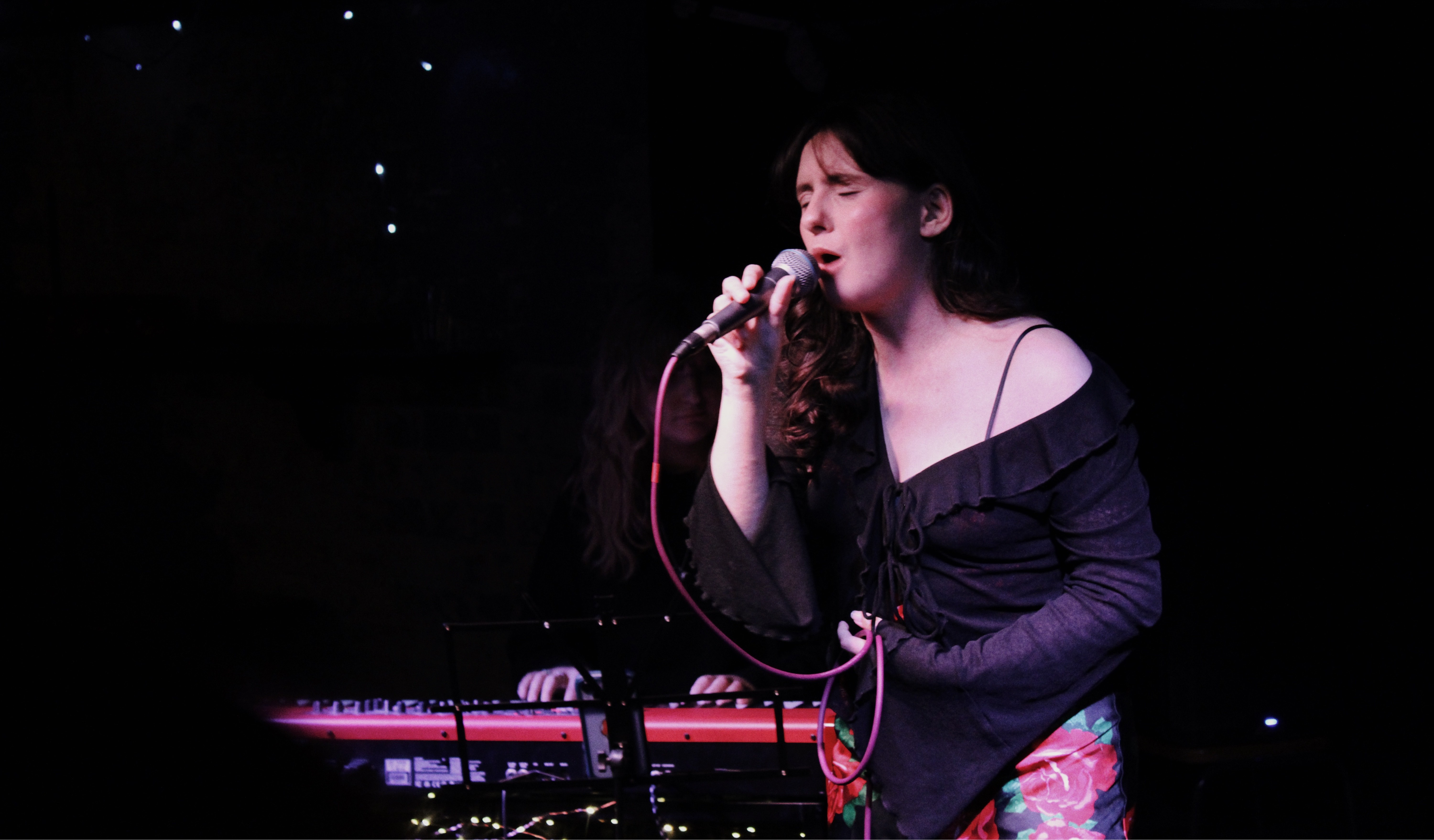 Kiera singing into a microphone on stage