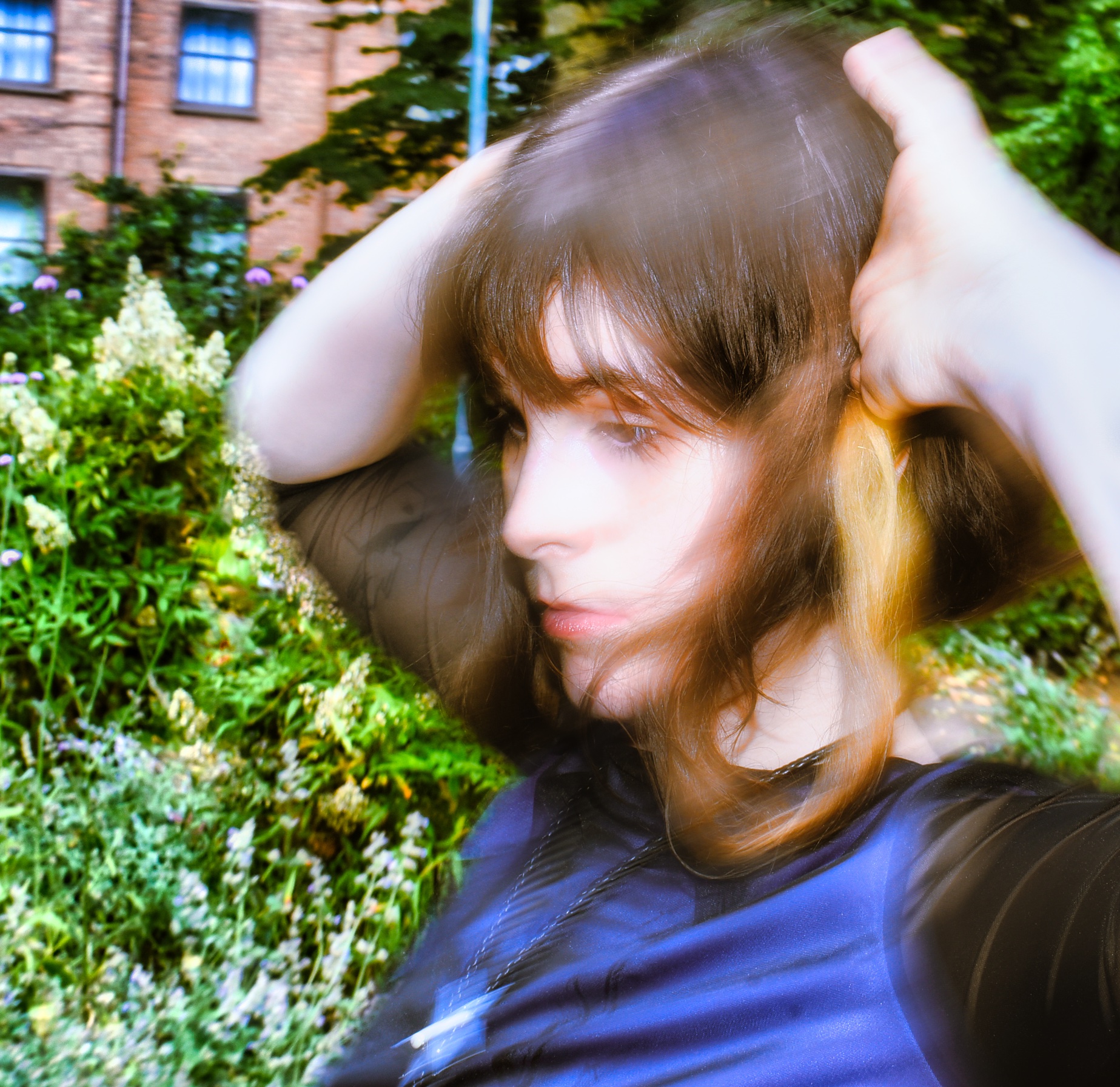 an artisticly blurred photo of Celeste's face with her hands on her head