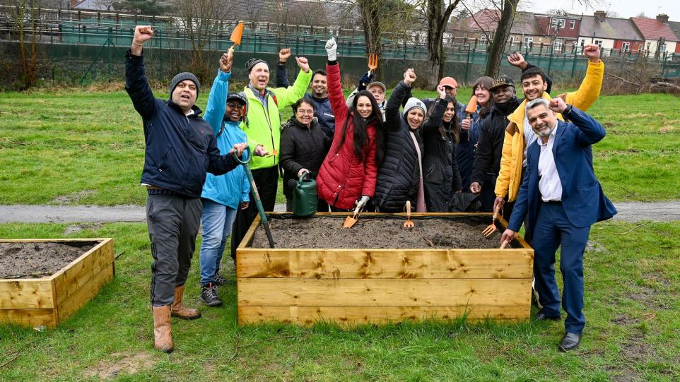 Evelyn and community members in the garden smiling at the camera