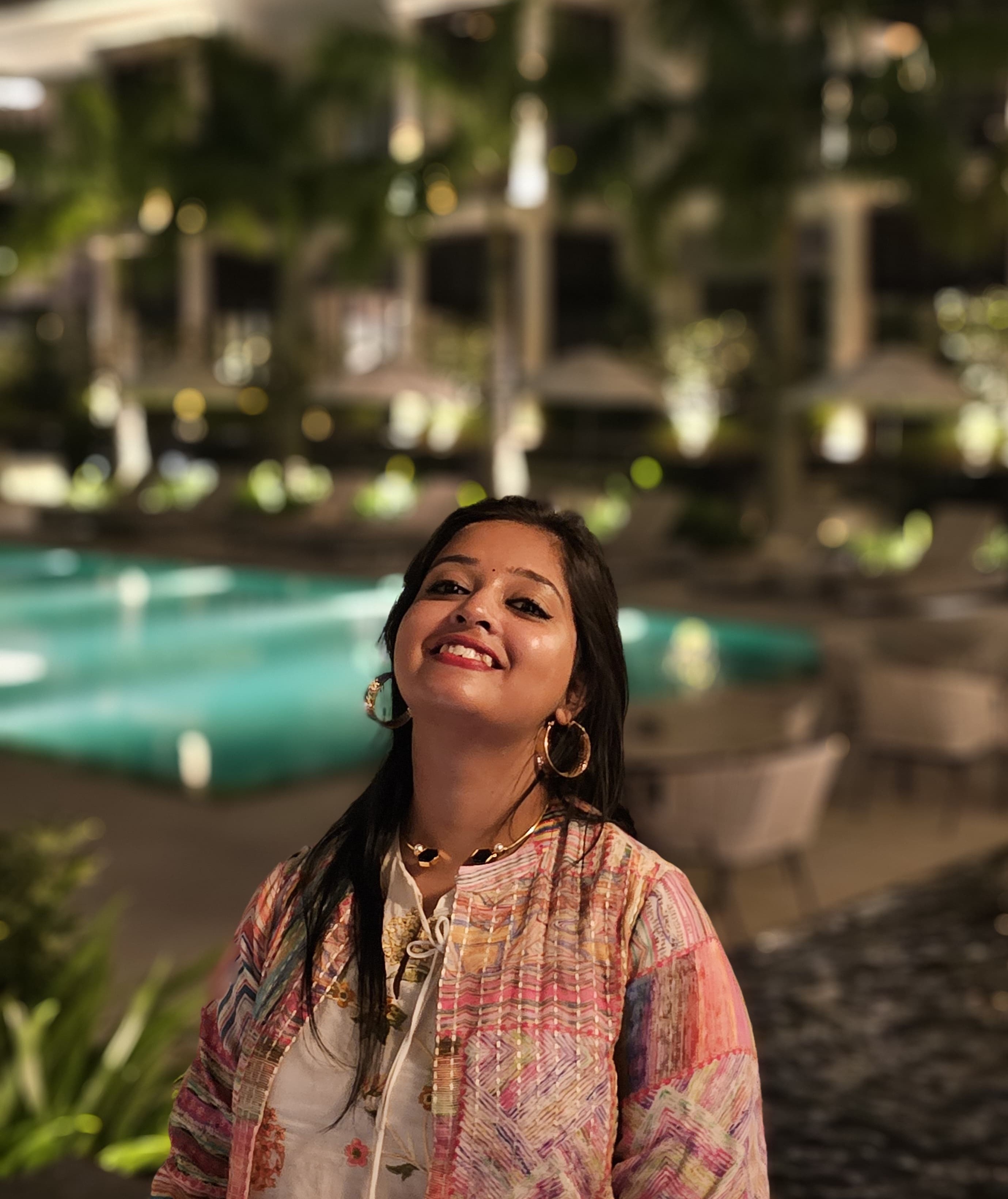 Srijani smiling for the camera with a night time background