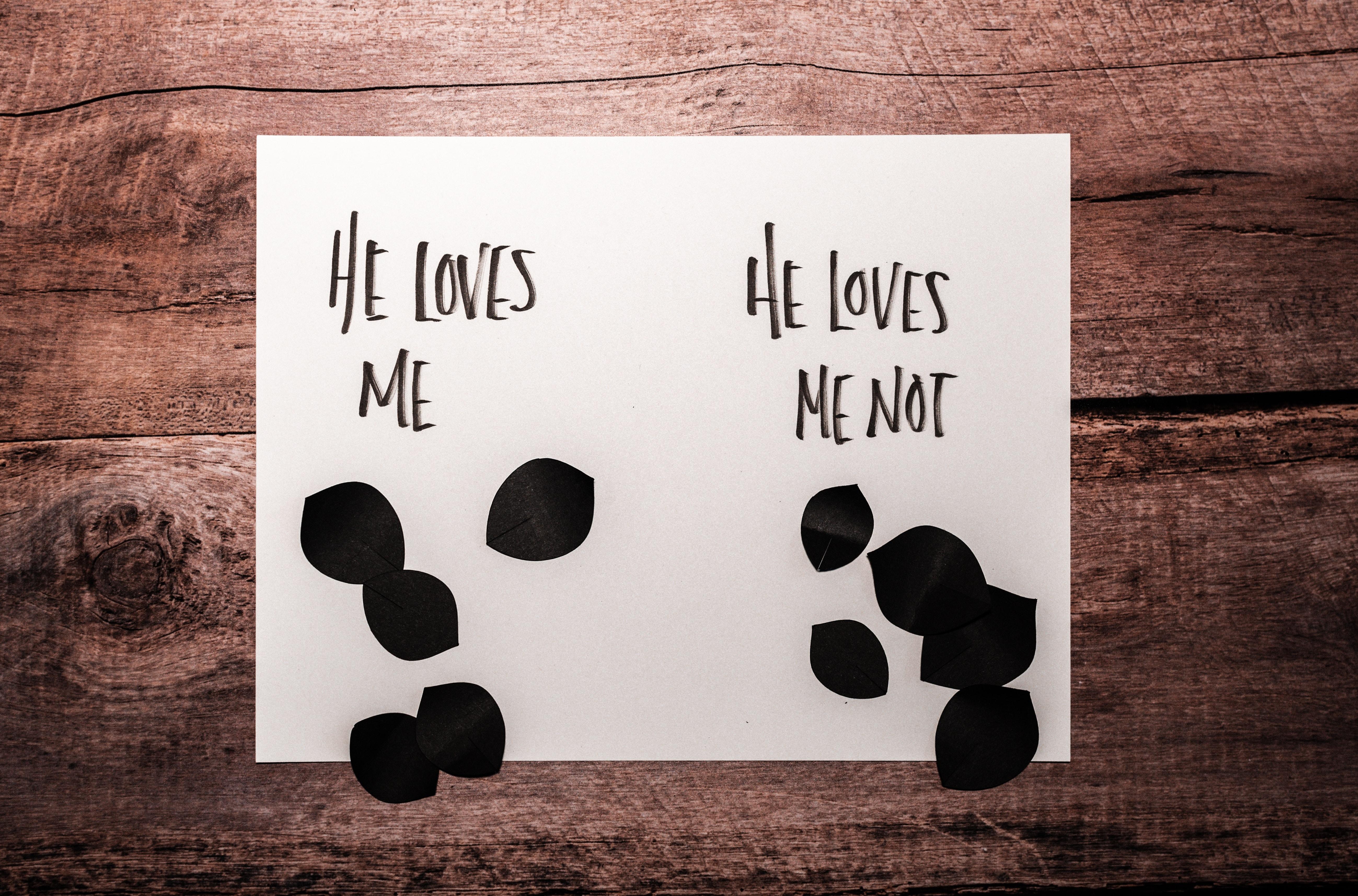 one paper saying he loves me and another paper saying he loves me not