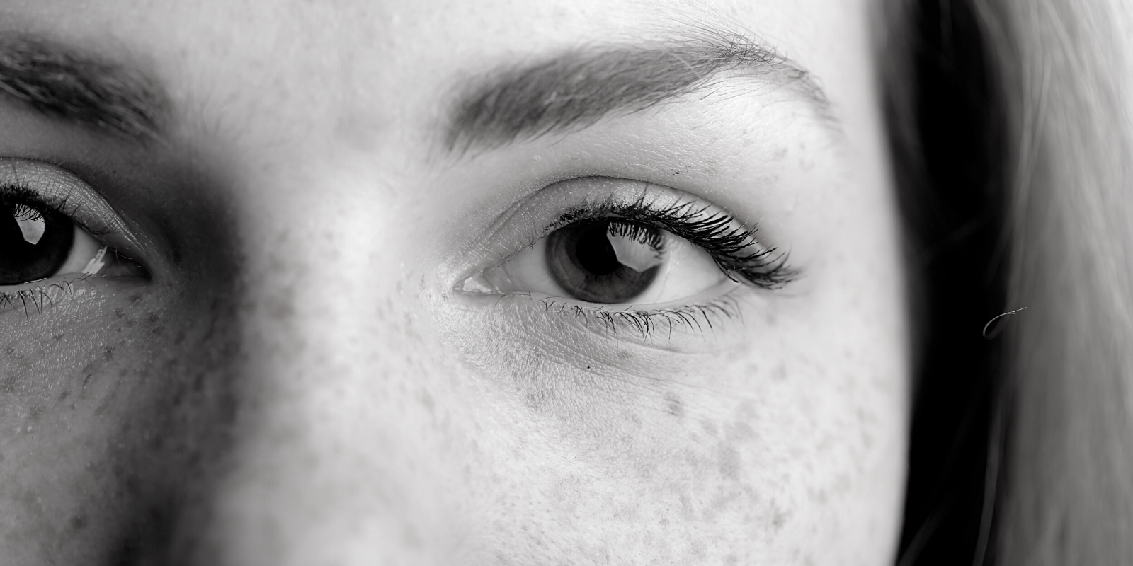 a closeup of a woman's eyes in grayscale