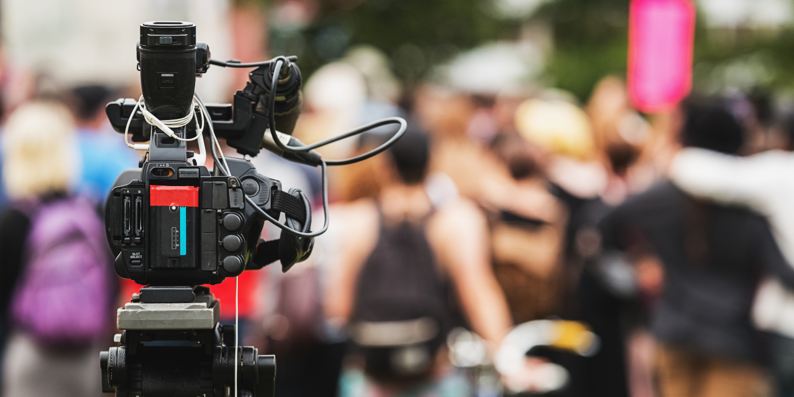 news camera pointed at a group of people
