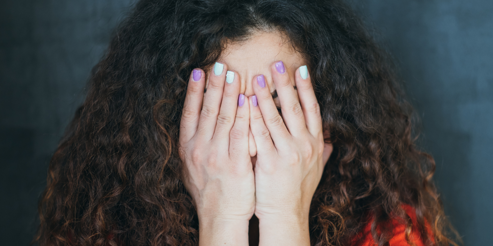 young woman covering her face