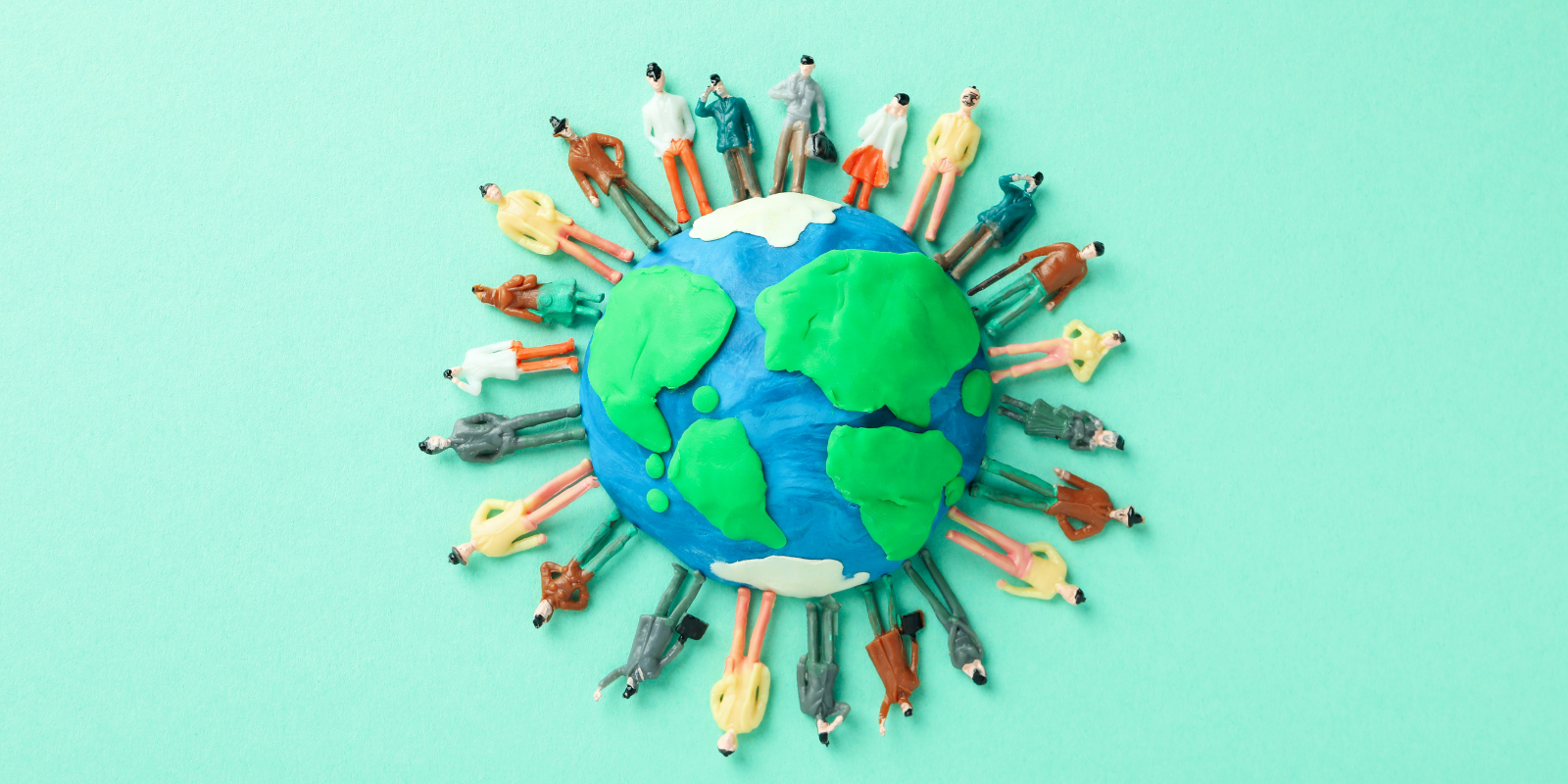 clay people standing around a clay model of the earth