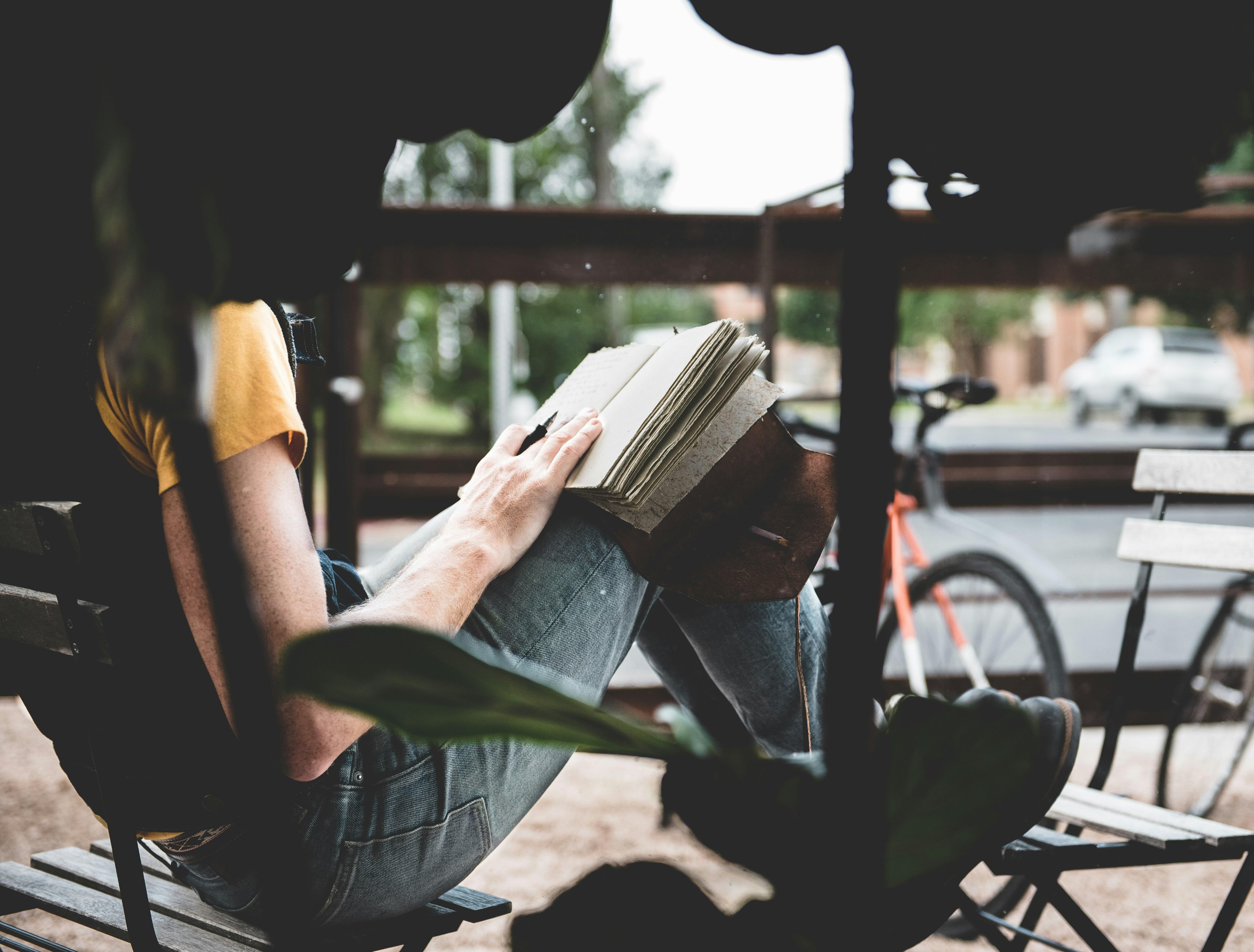 woman sitting on a bench writing 