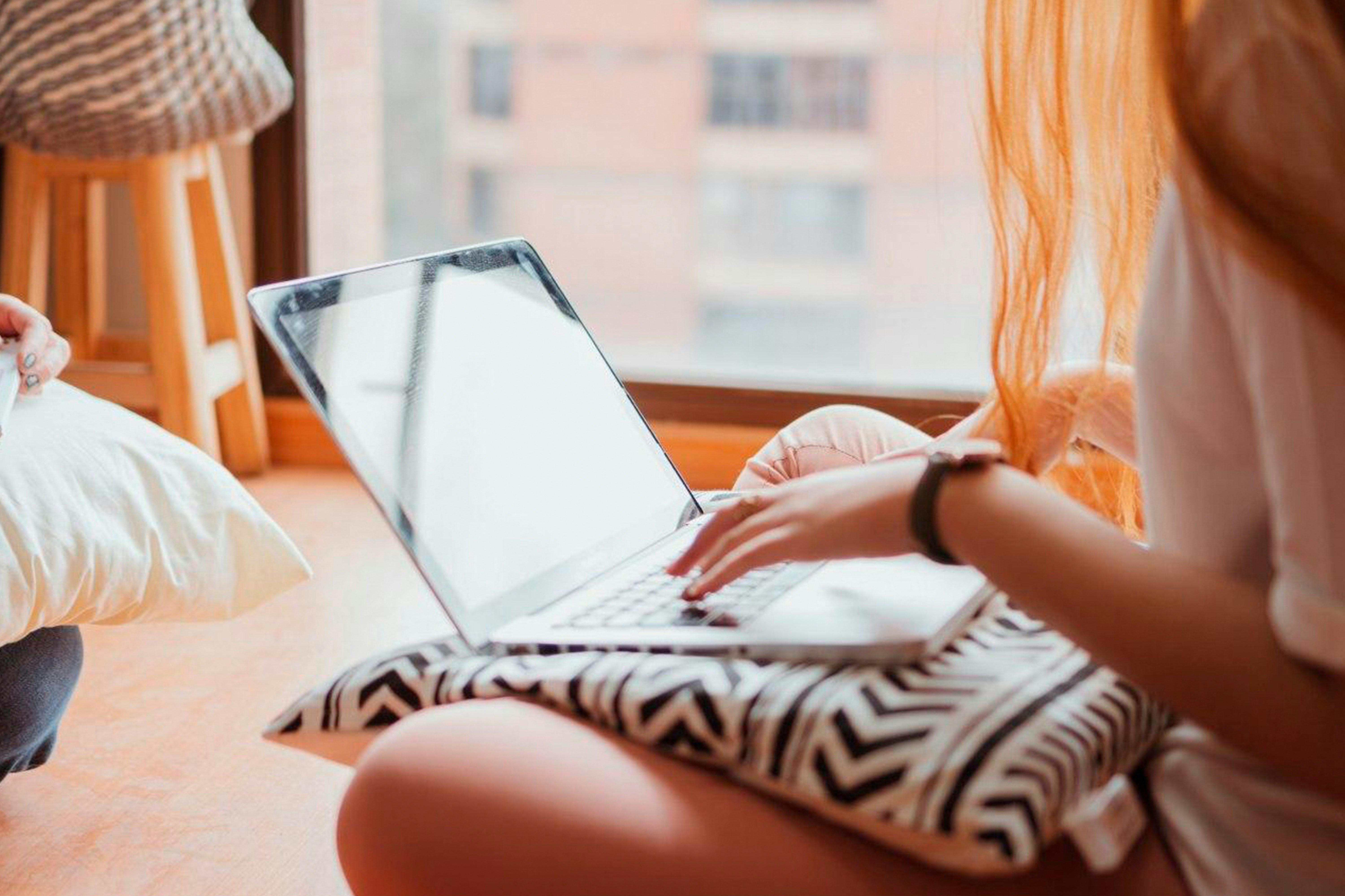 young woman typing on a laptop