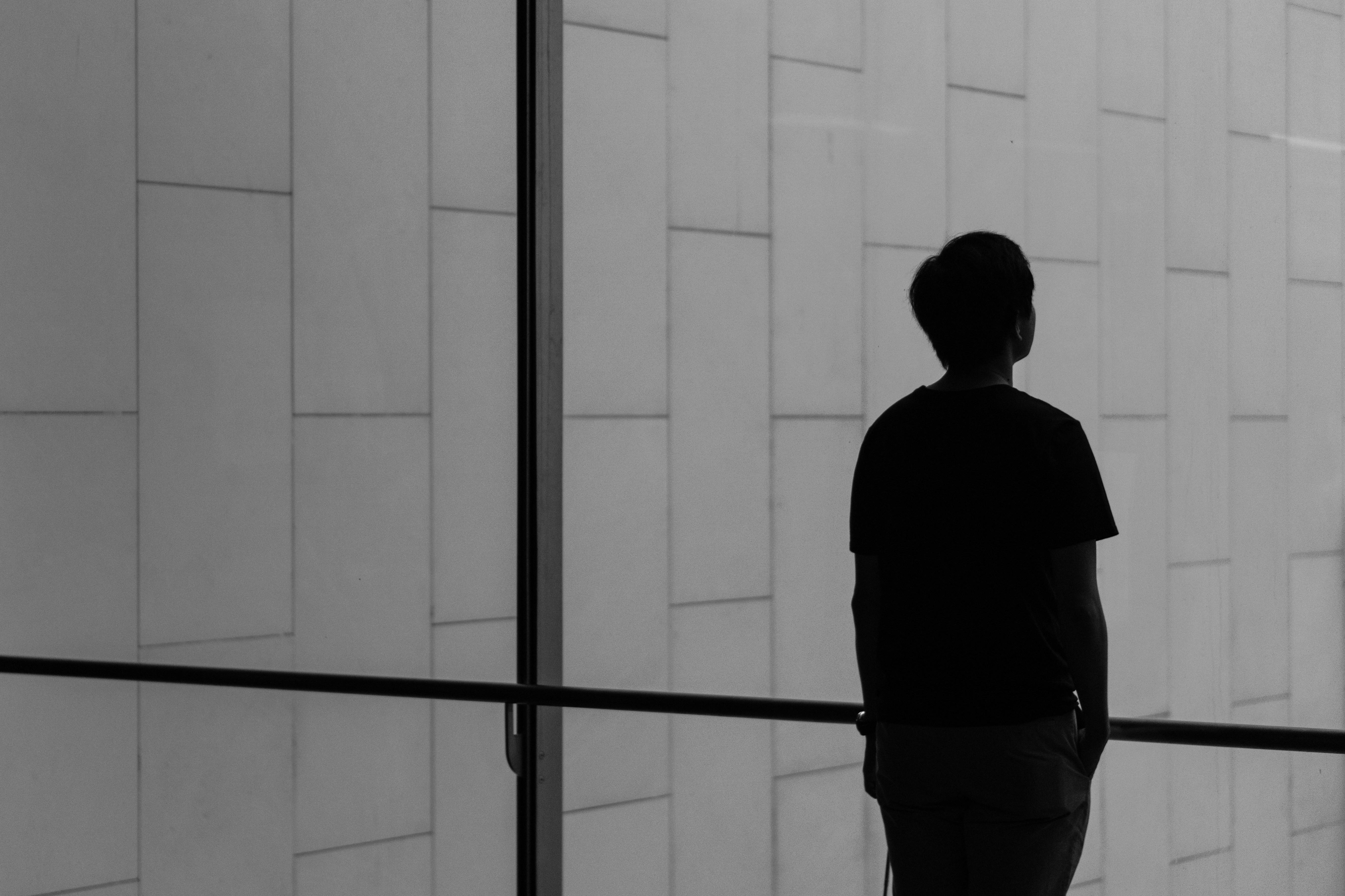 silhouette of a person standing in front of a window alone