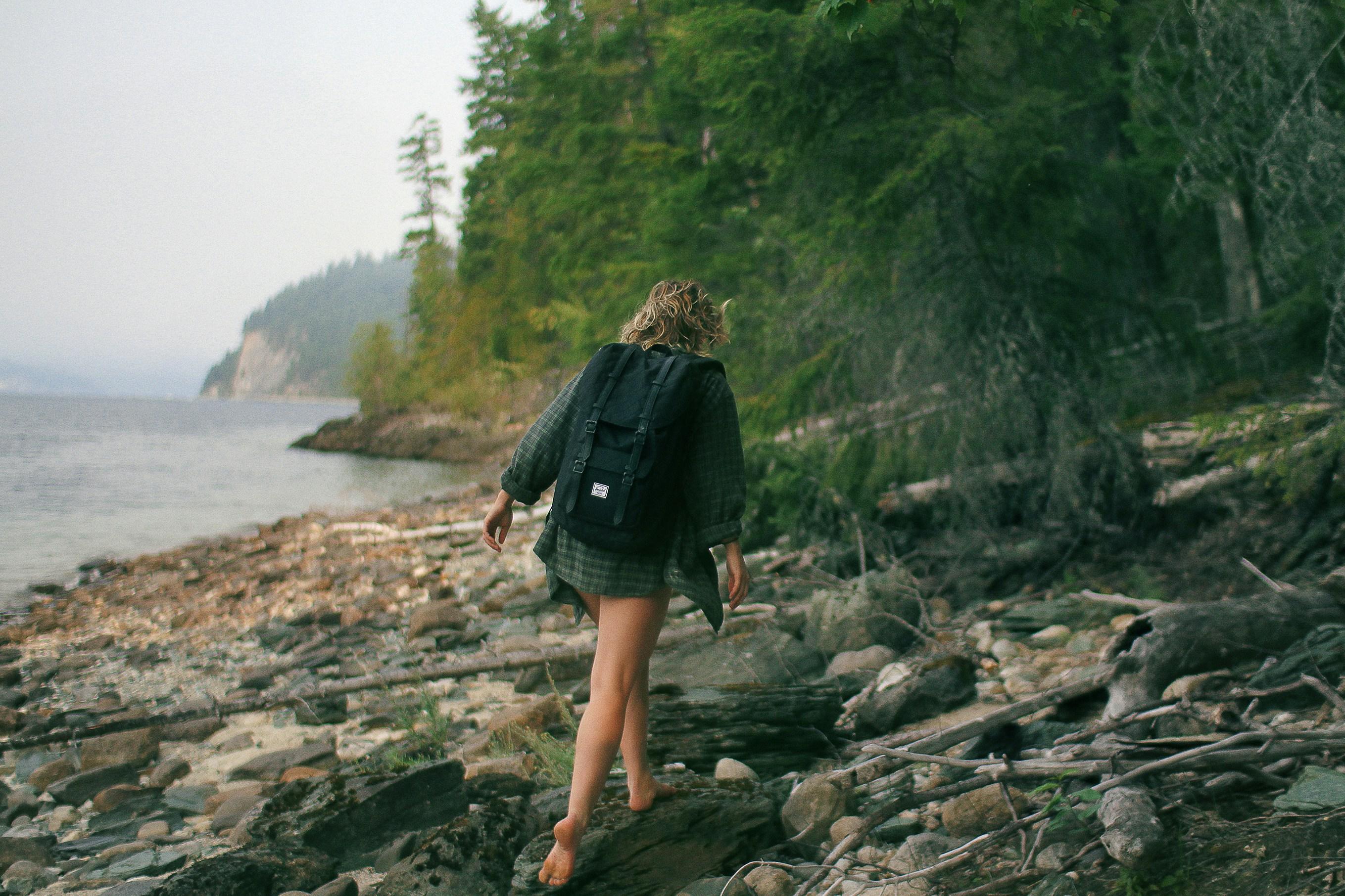 woman wearing a backpack walking away