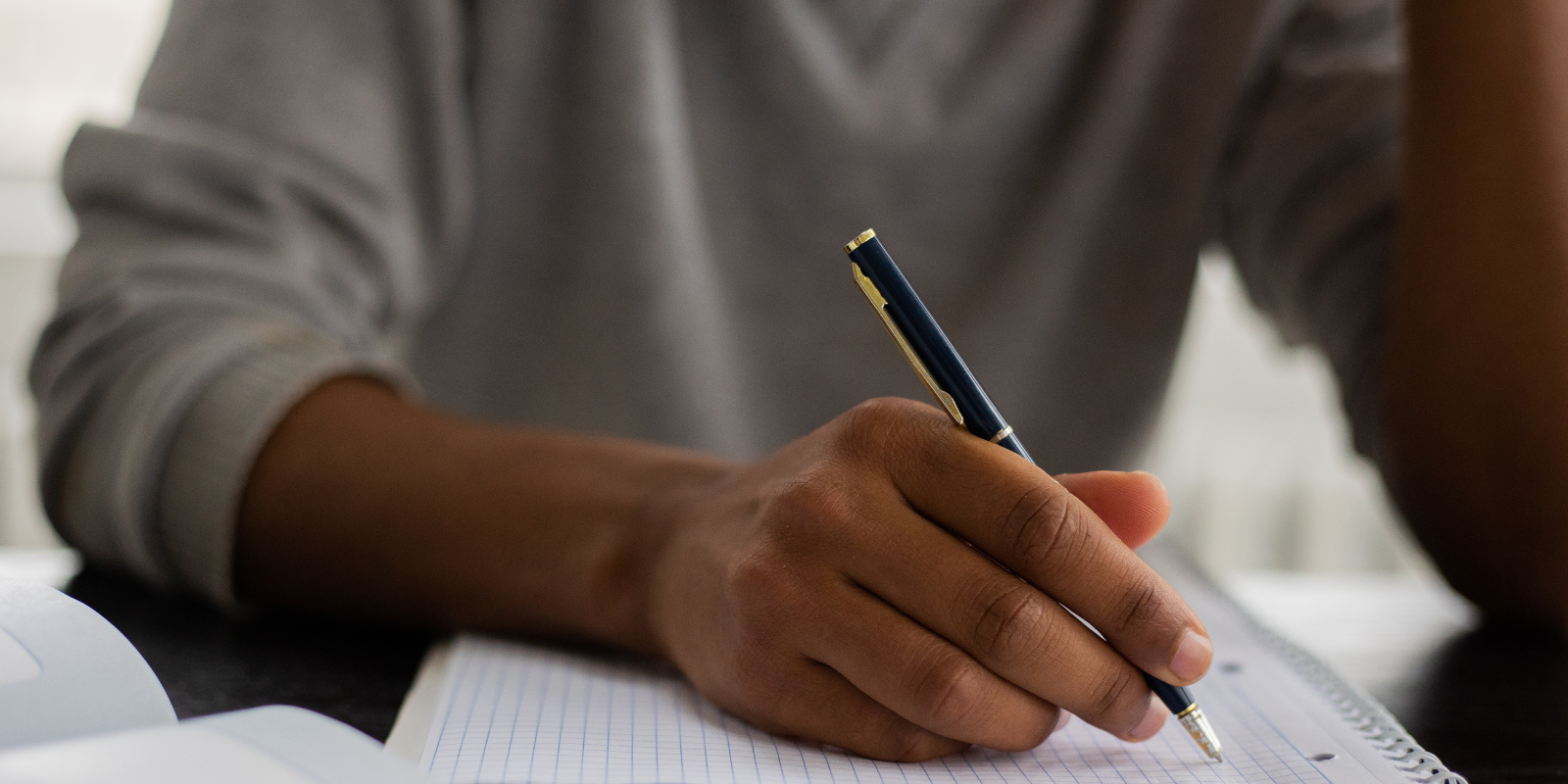 young man writing in a notebook