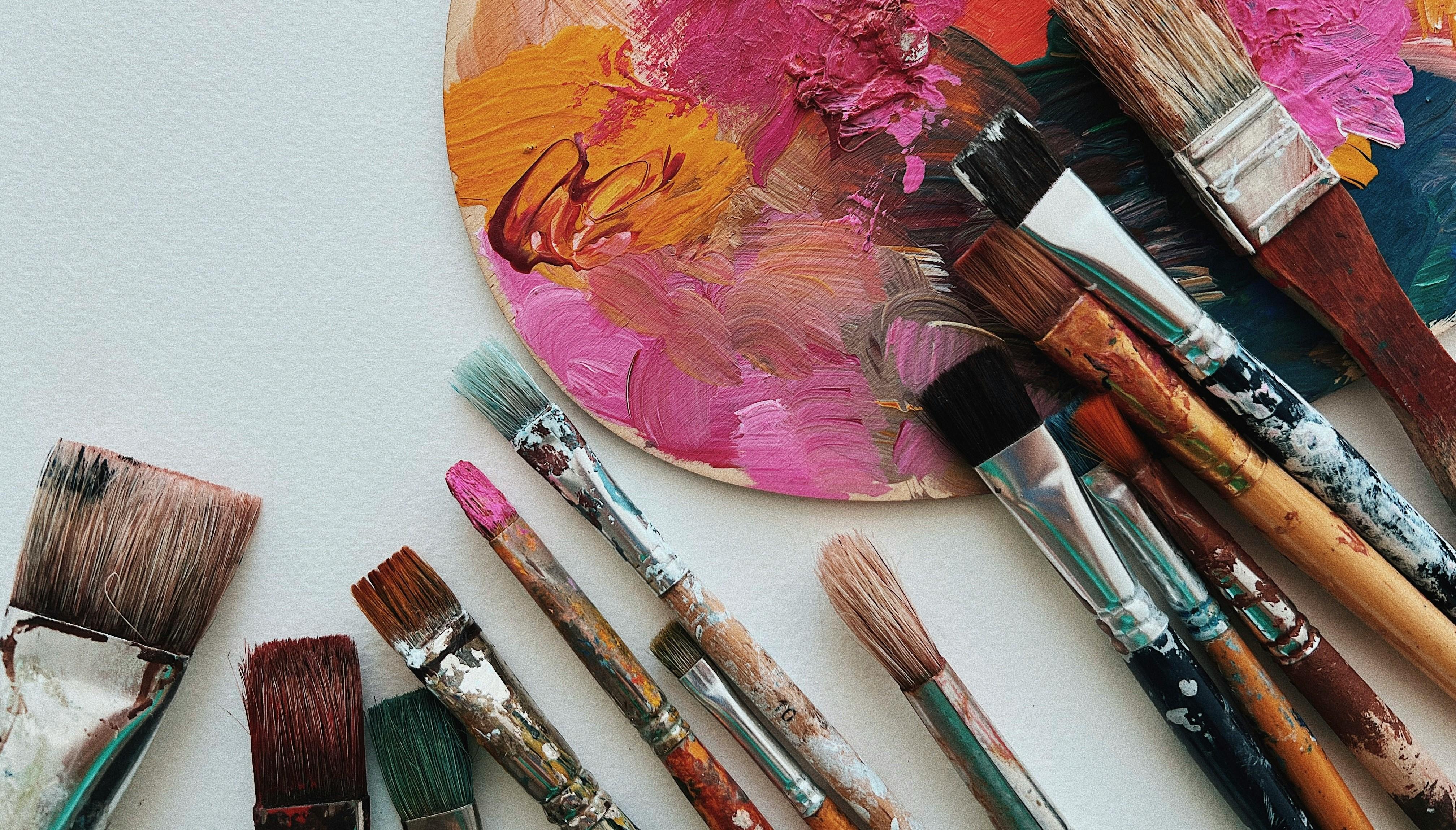 paint brushes and paint covered palette