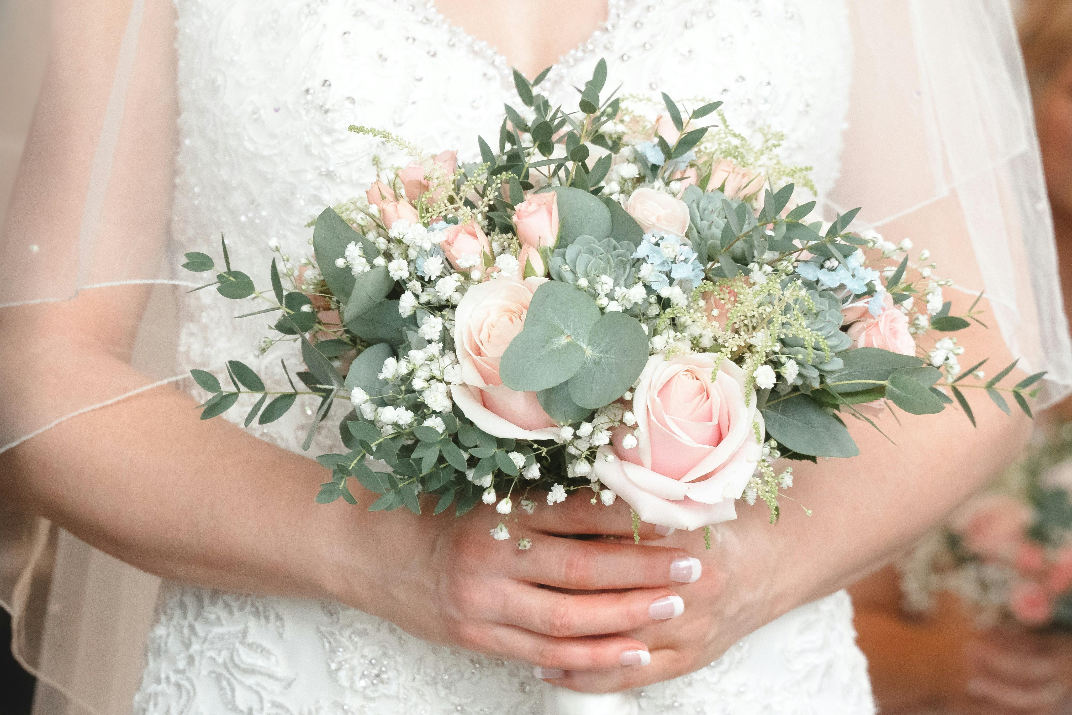 a woman in a wedding dress holding a bouquet of flowers