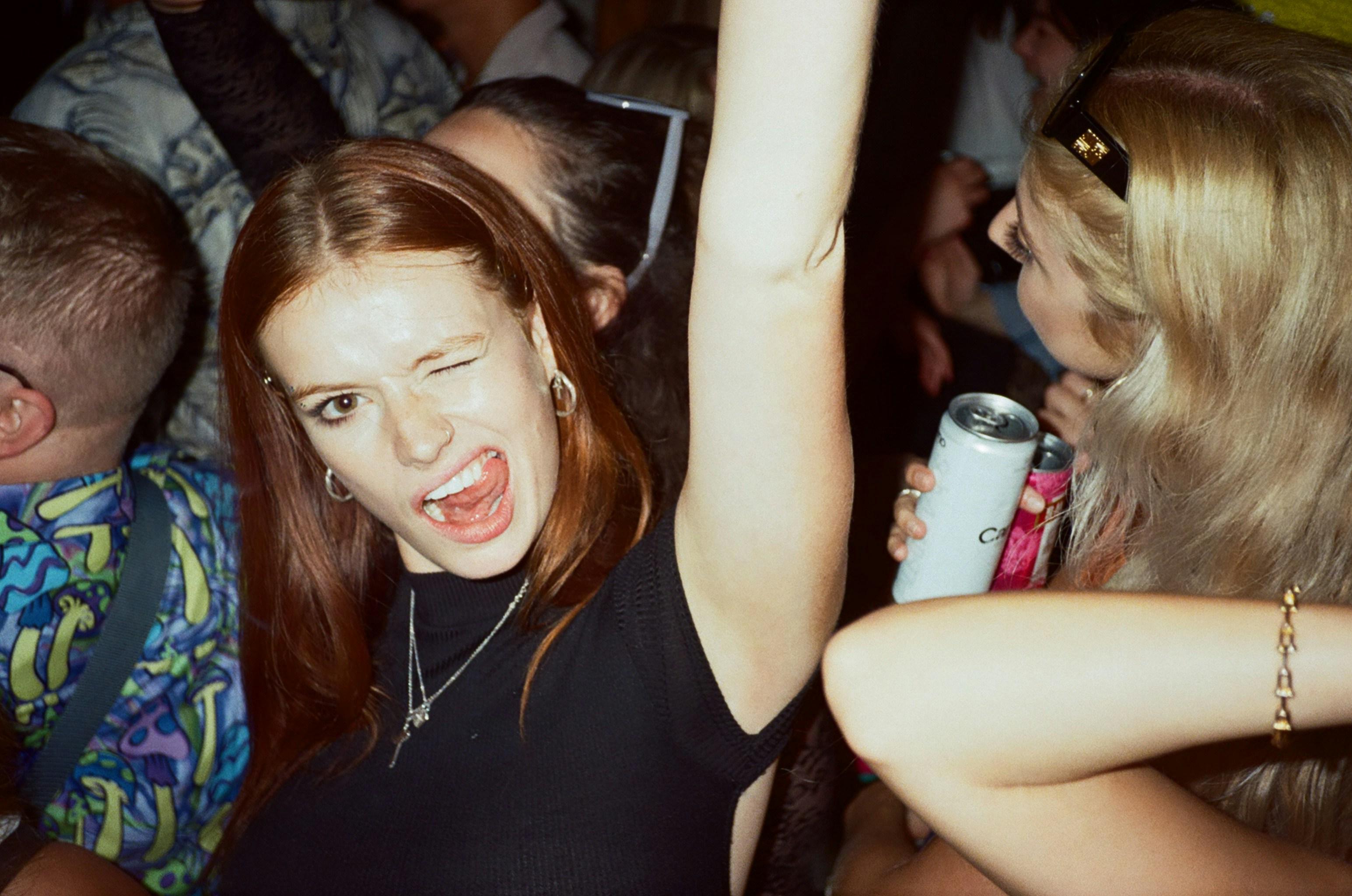 a group of people at the party with one woman looking into the camera winking