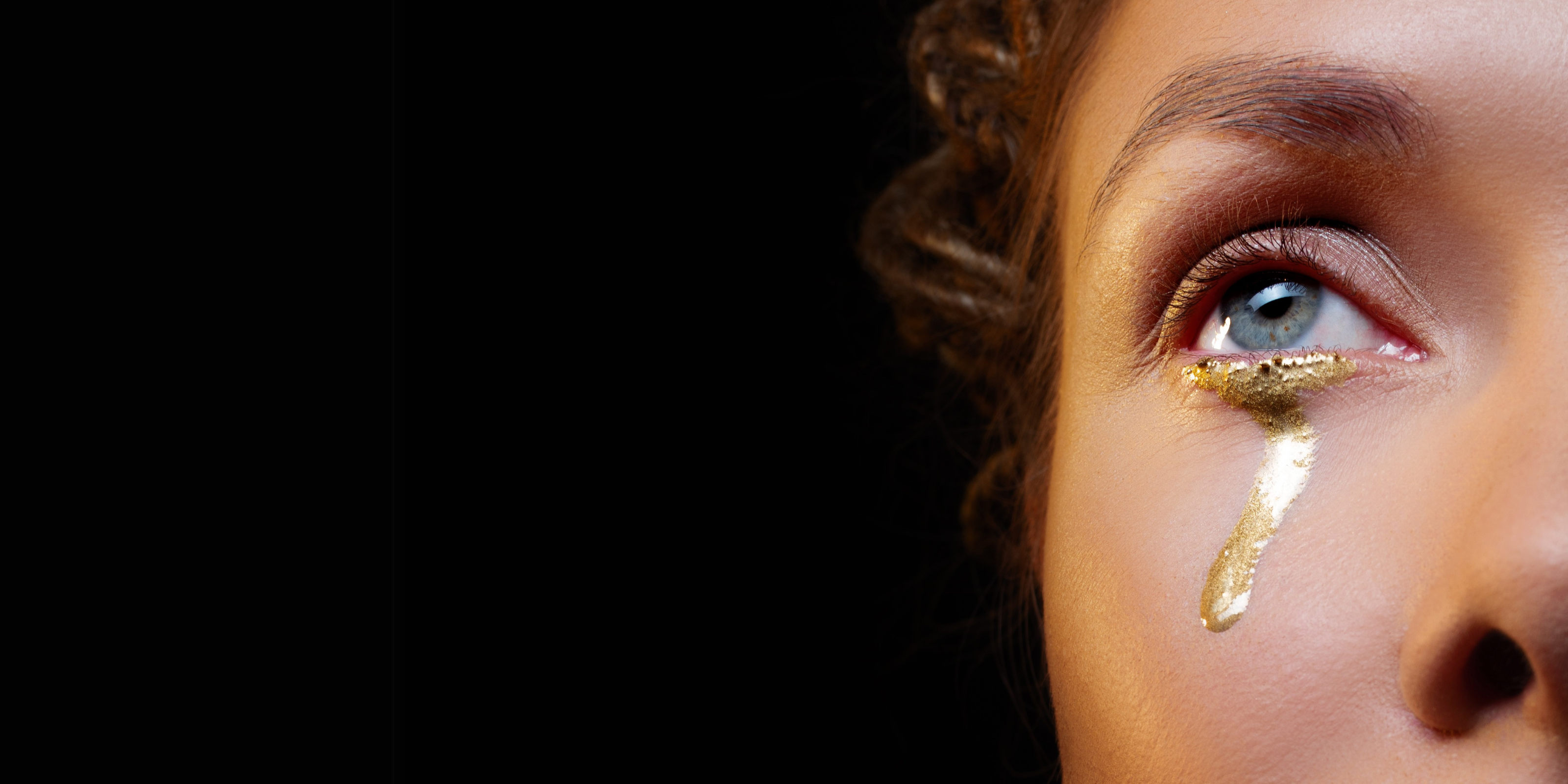 gold tears on a womans face