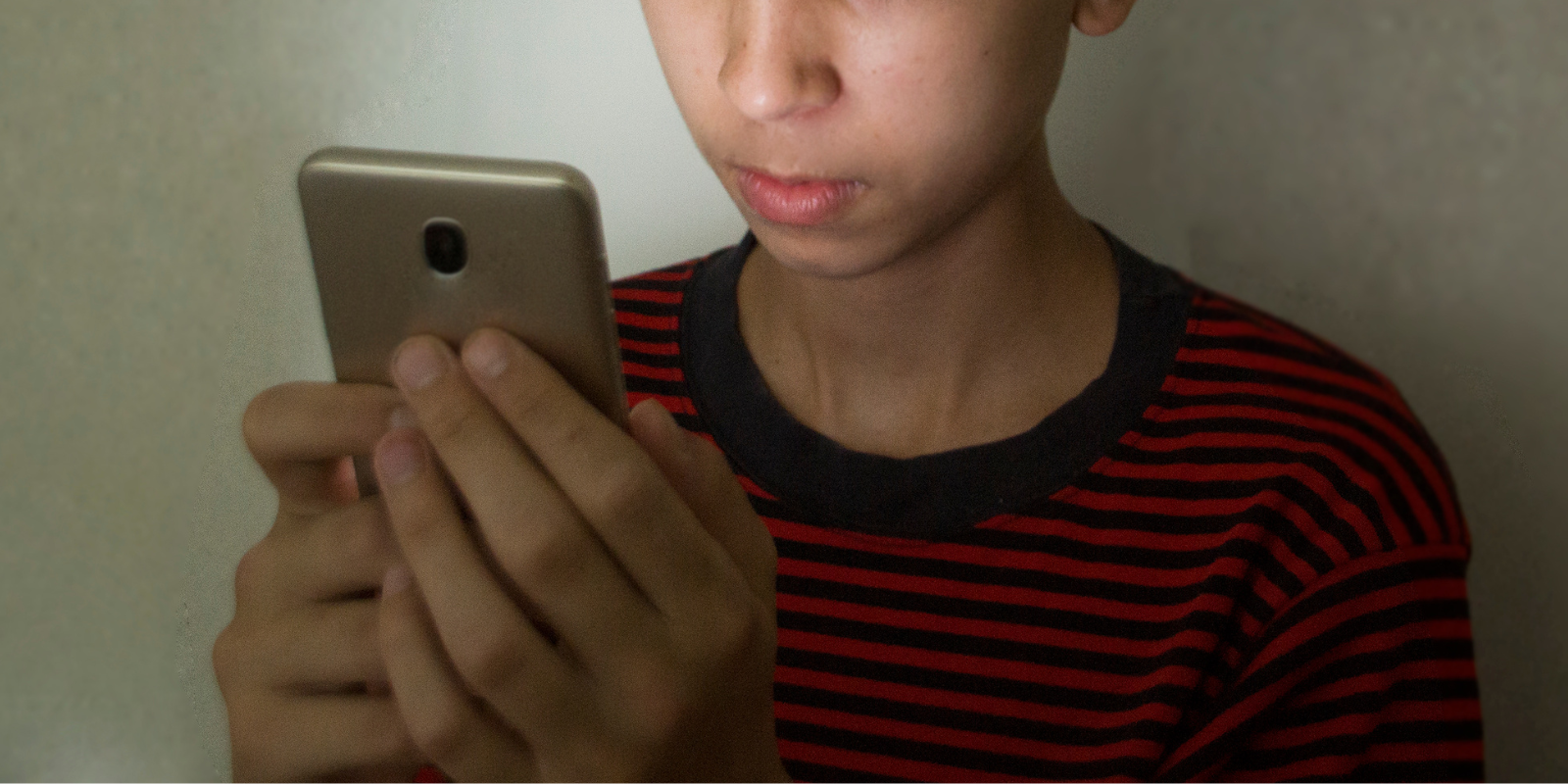 a teen boy looking at his phone