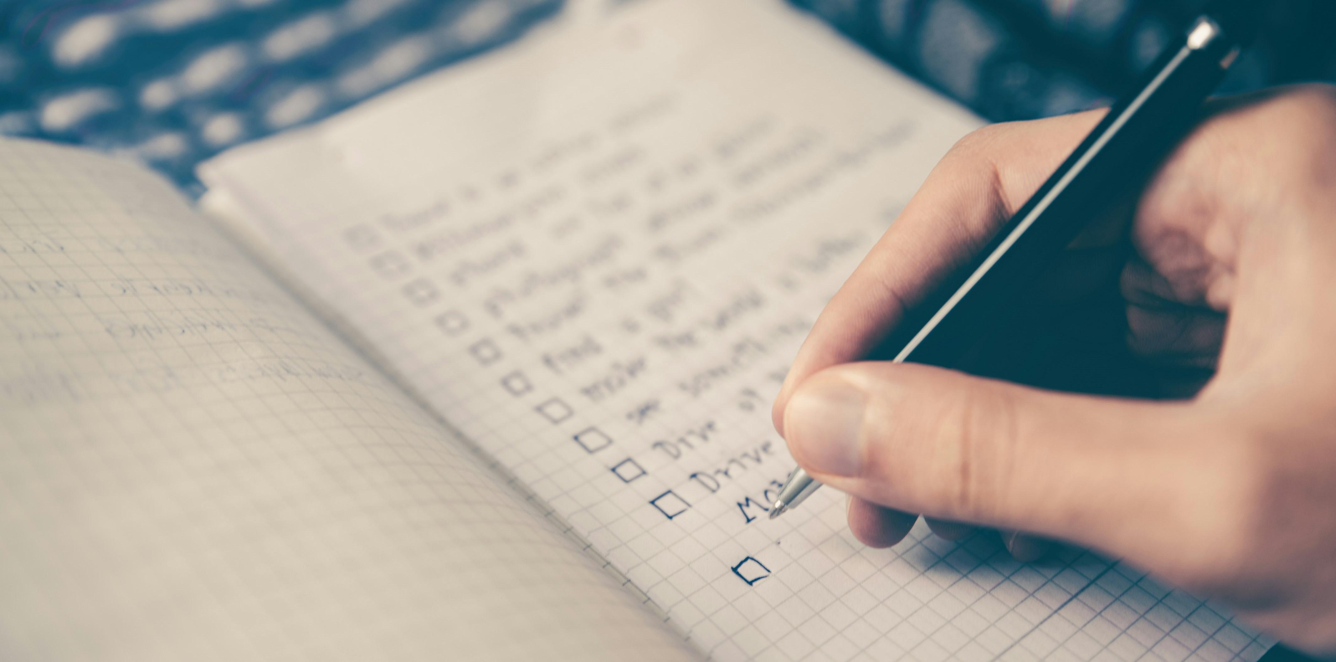 person writing a to do list 