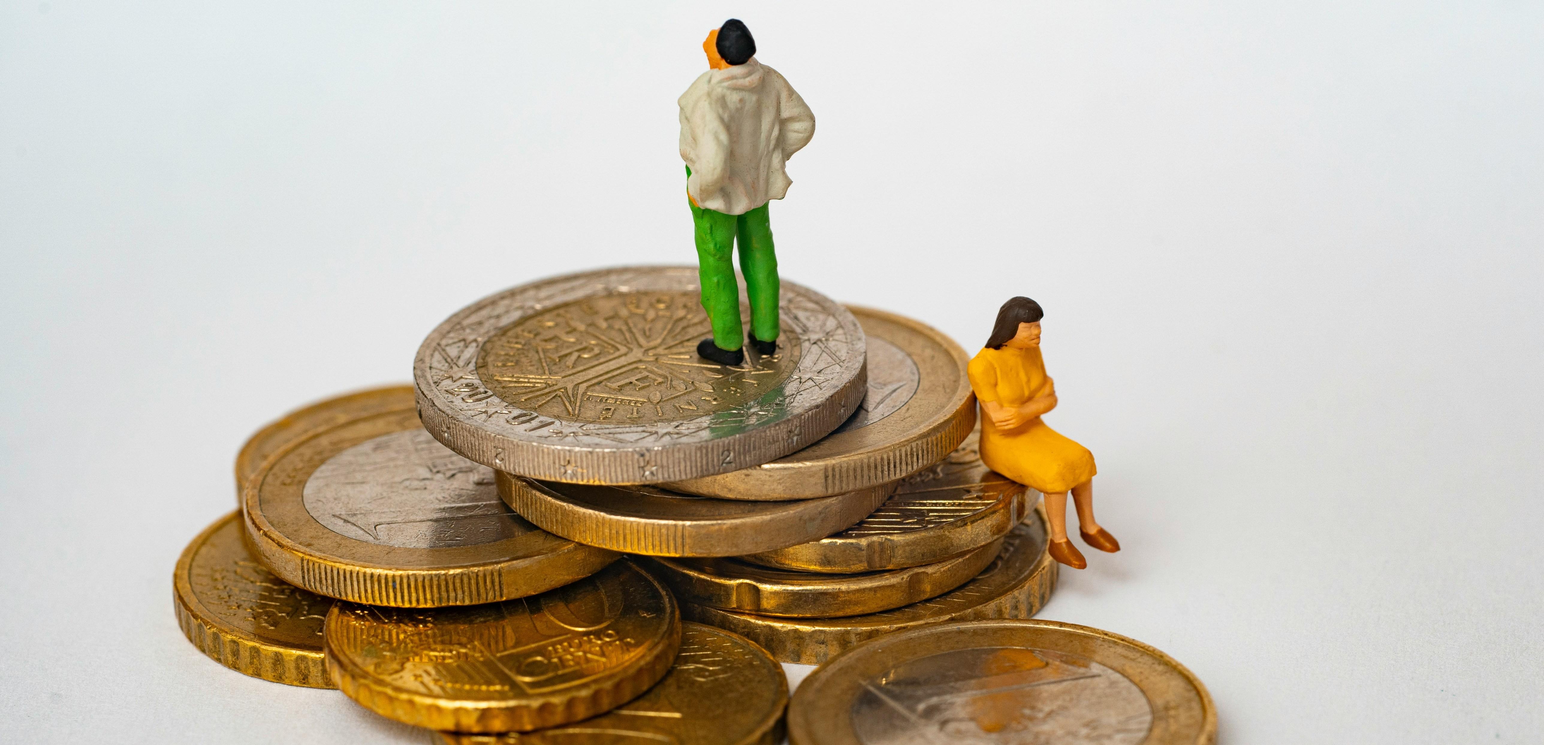 figurines looking angry sitting on a pile of coins