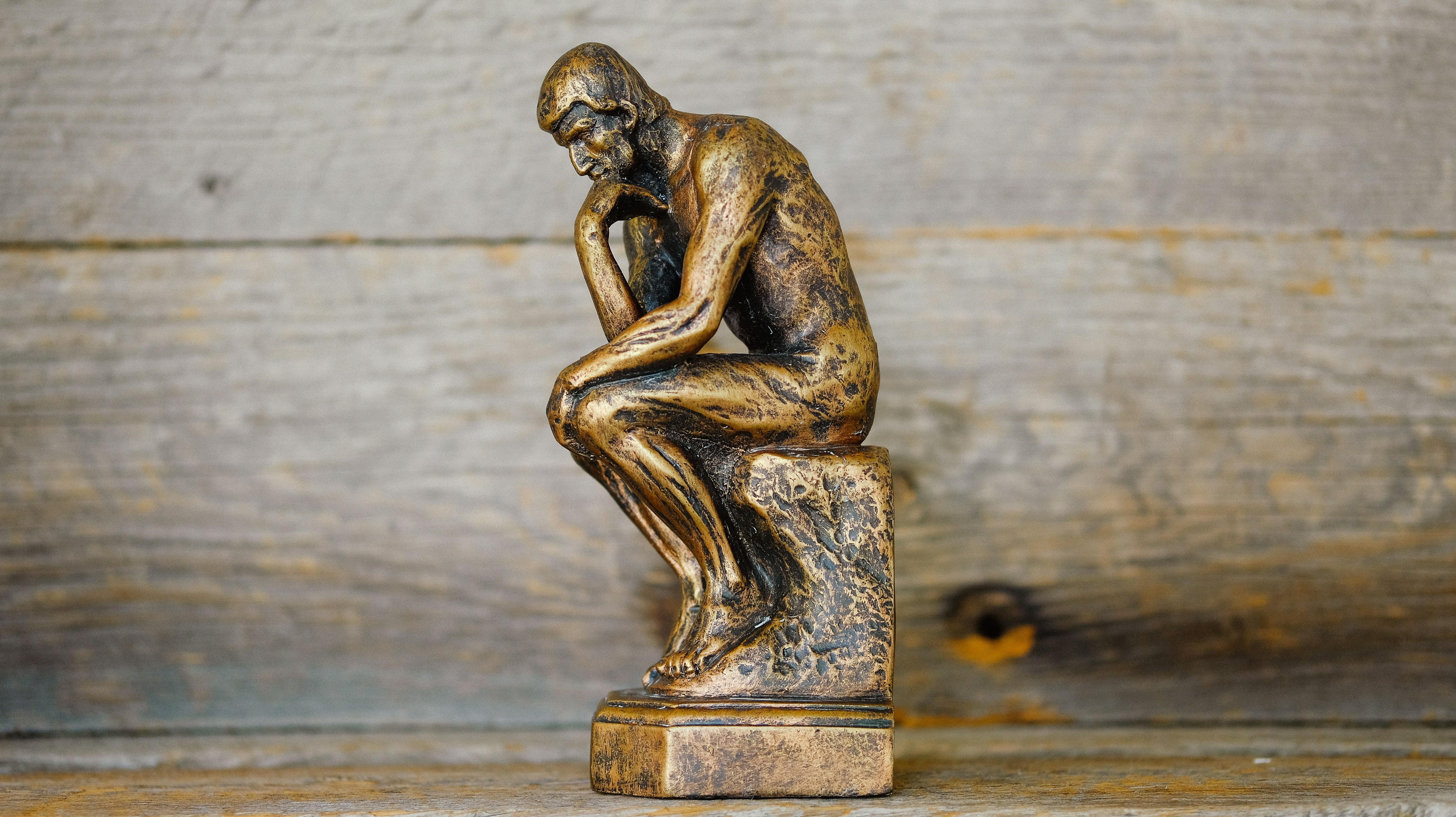 bronze statue of a man thinking 