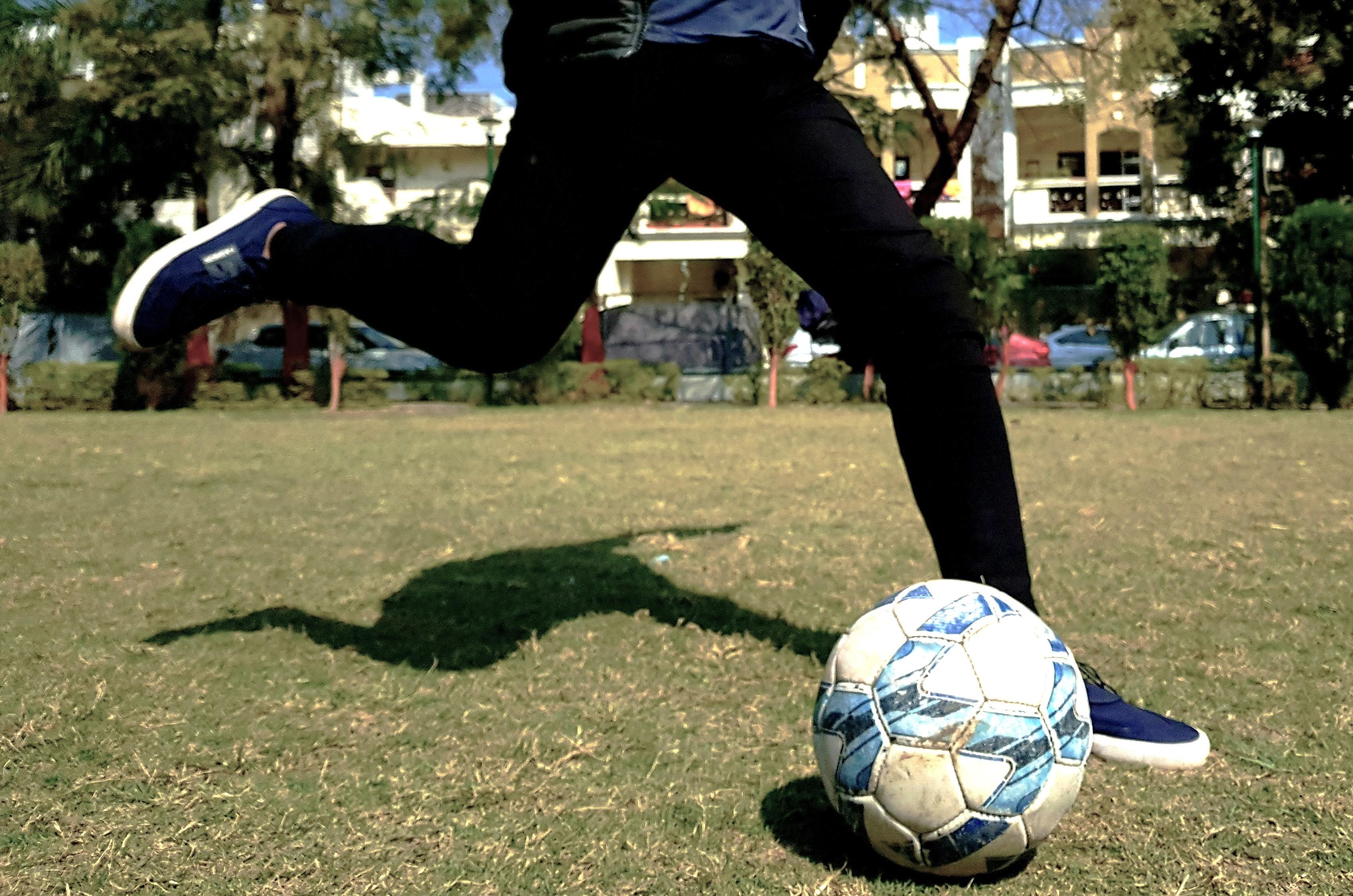 teen boy kicking football