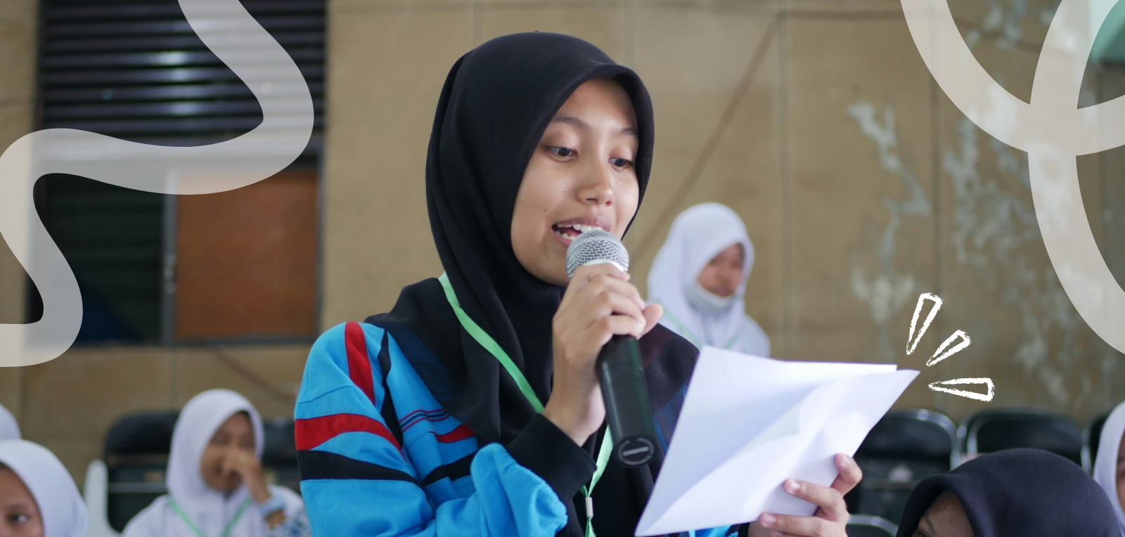 young woman talking on a microphone with a paper in her hand 