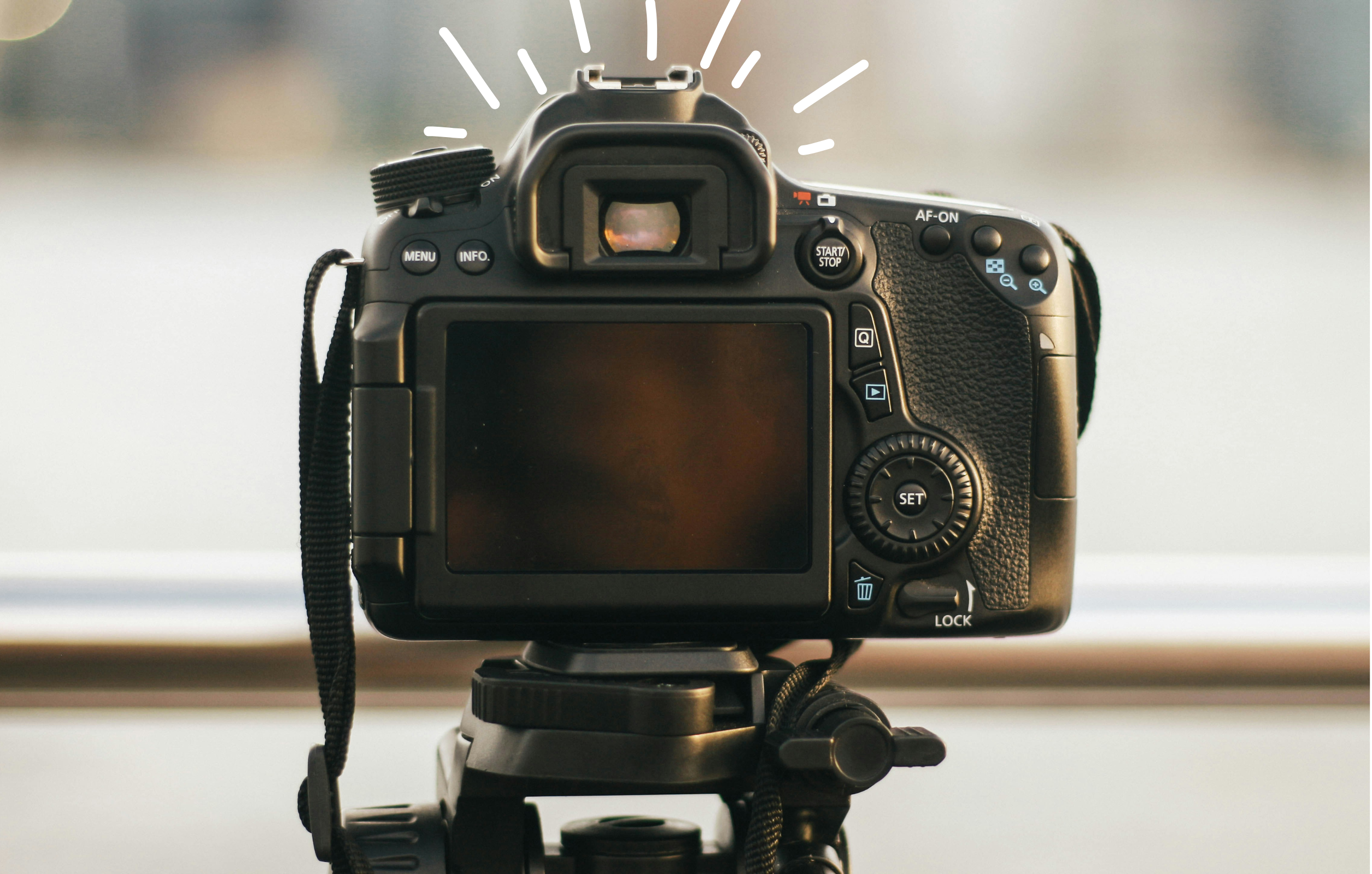 camera on a tripod with line doodles around the top