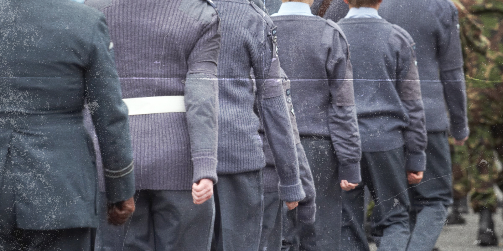student cadets in grey uniforms marching away from the camera