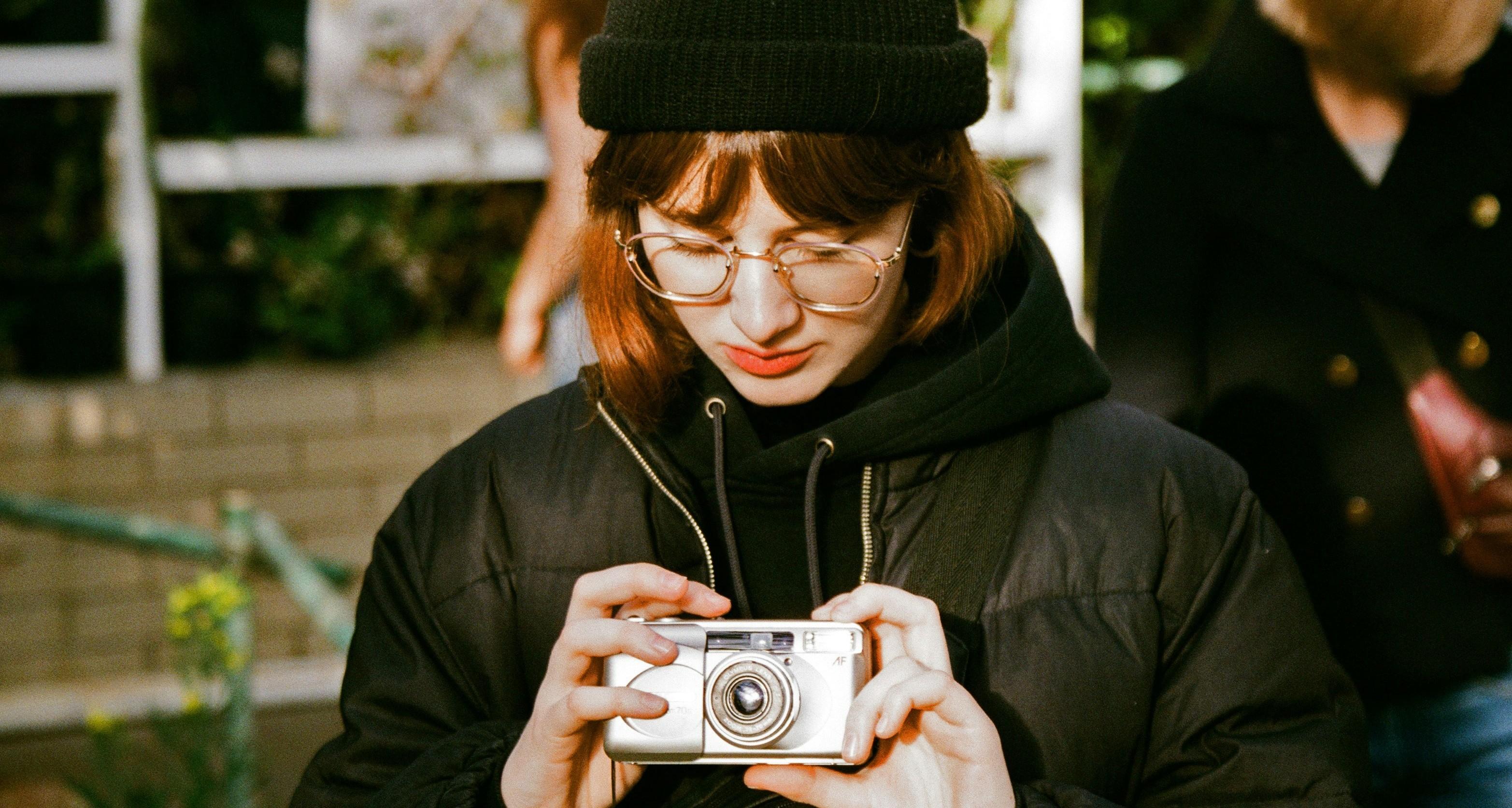 young woman holding a film camera
