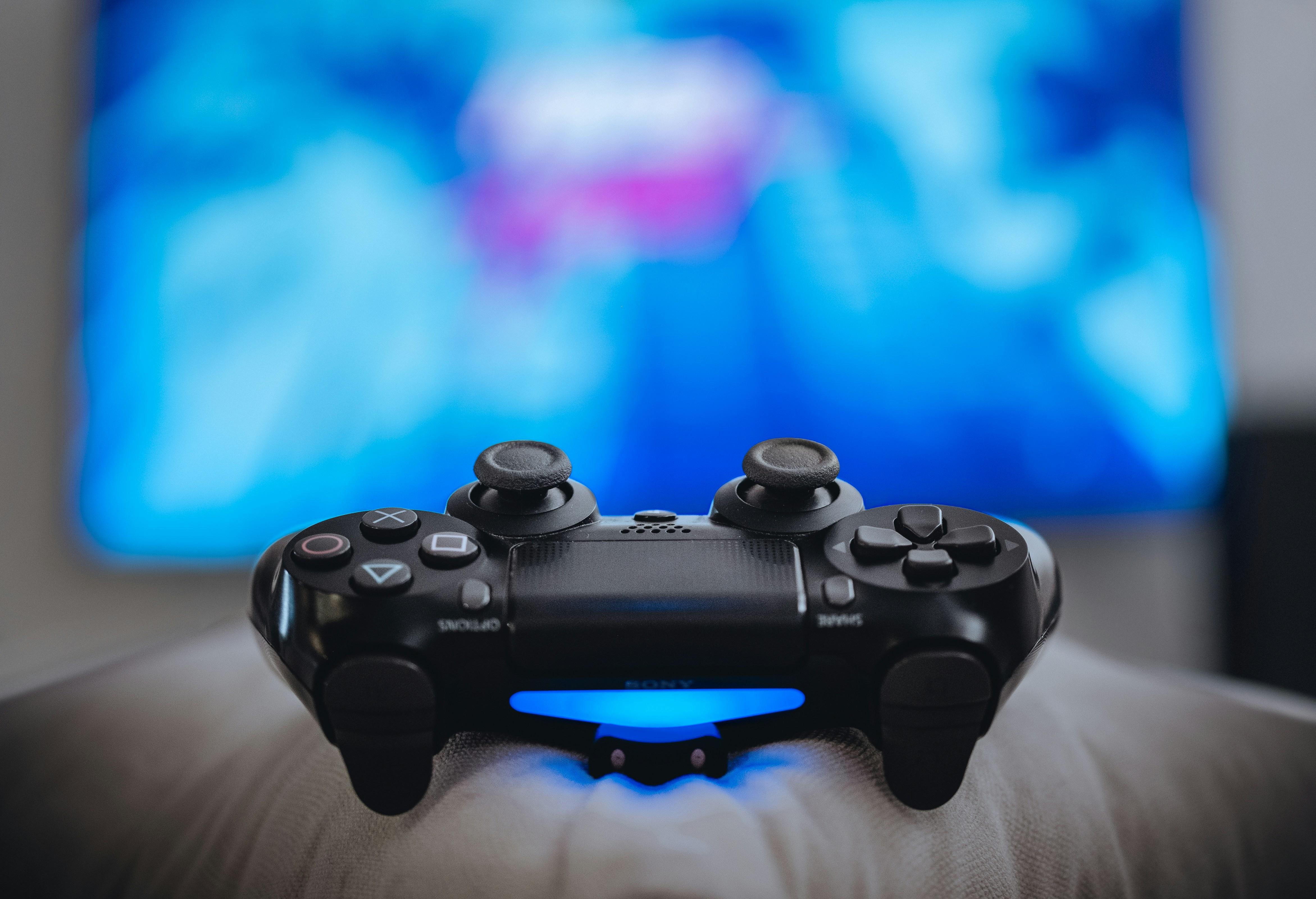 gaming remote in front of a lit screen