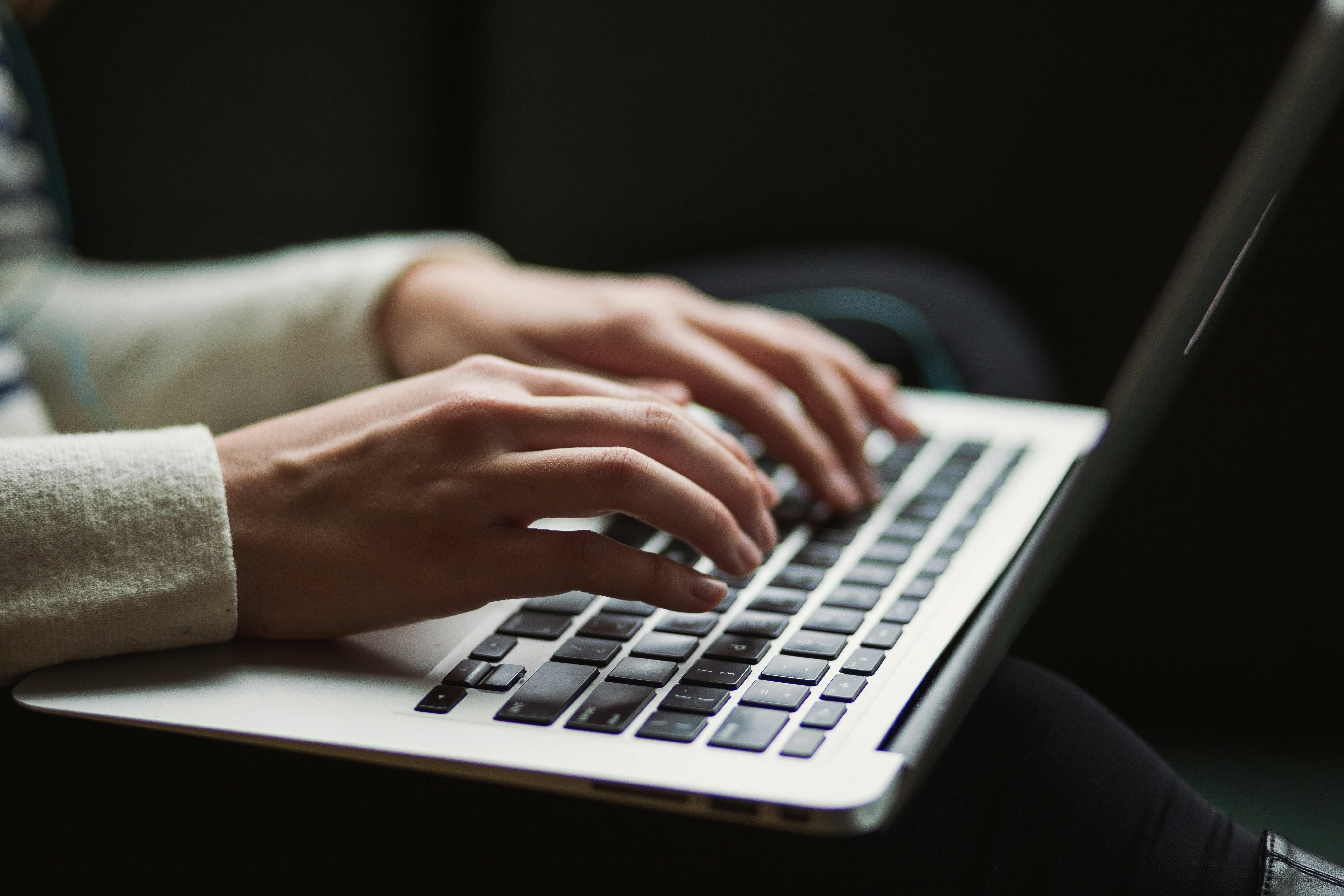 A cropped image of someone typing on a computer.