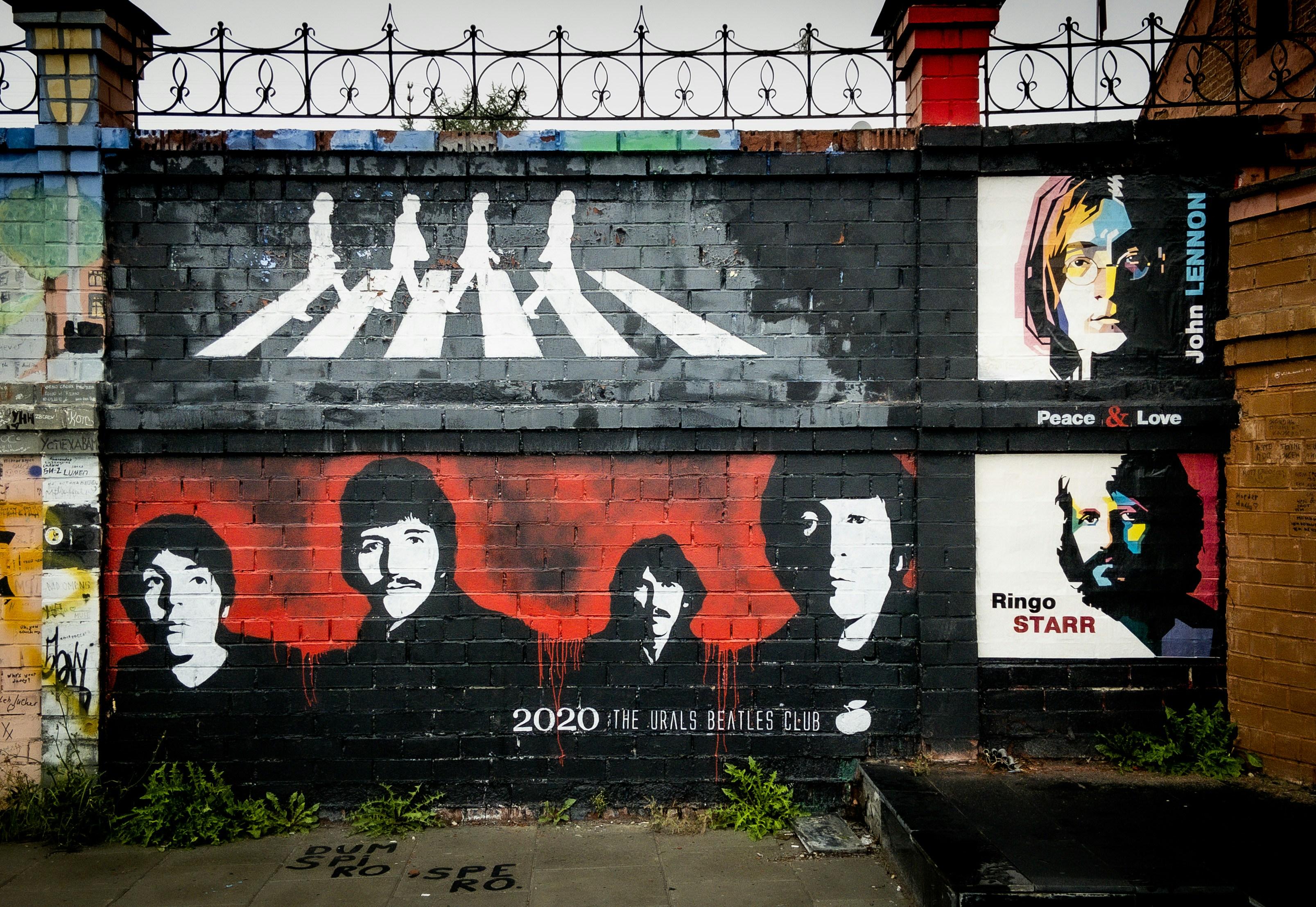 A photograph of a Beatles mural. The top half shows the Beatles on Abbey Road and the bottom half displays their faces.