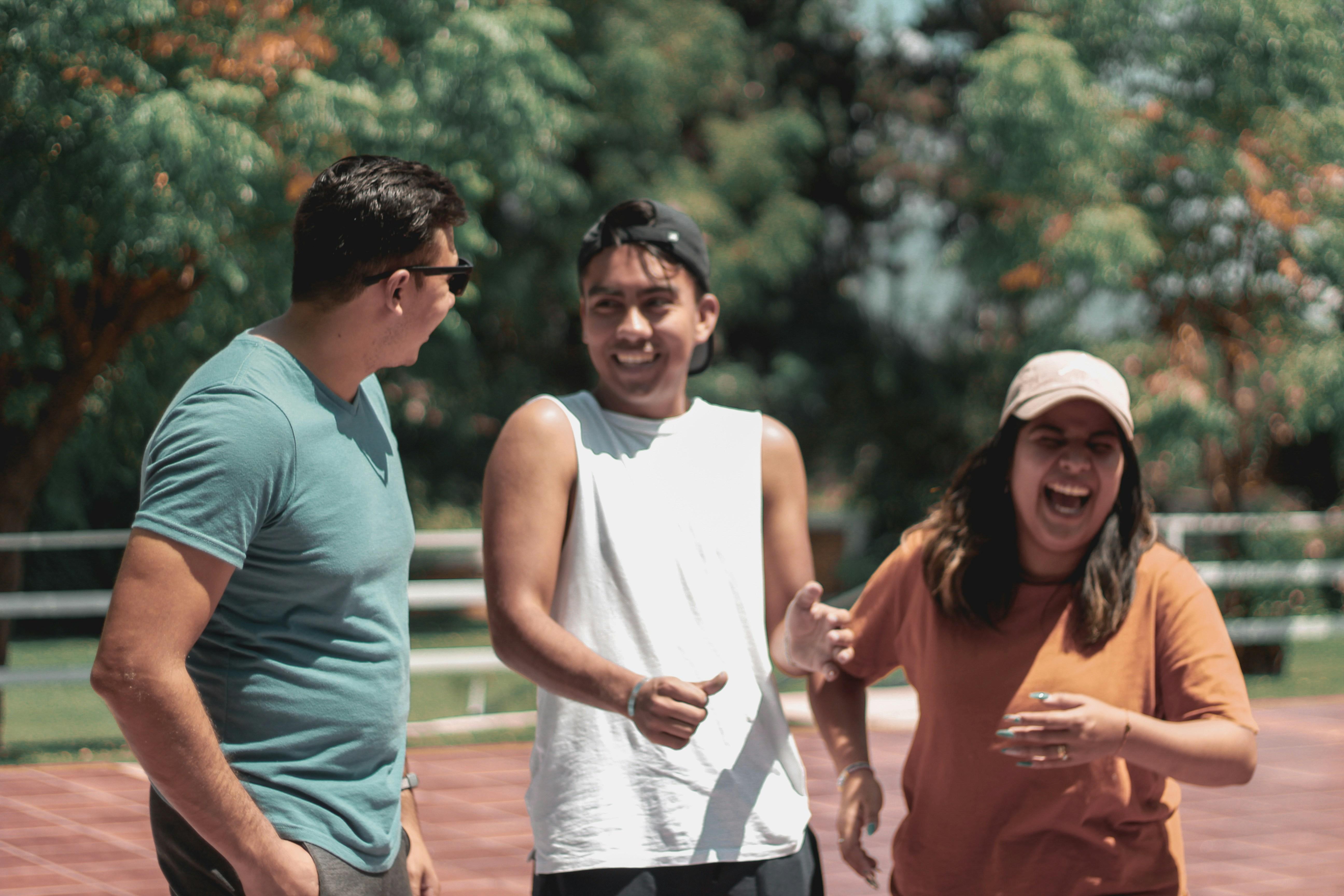 Three young adults laughing together.