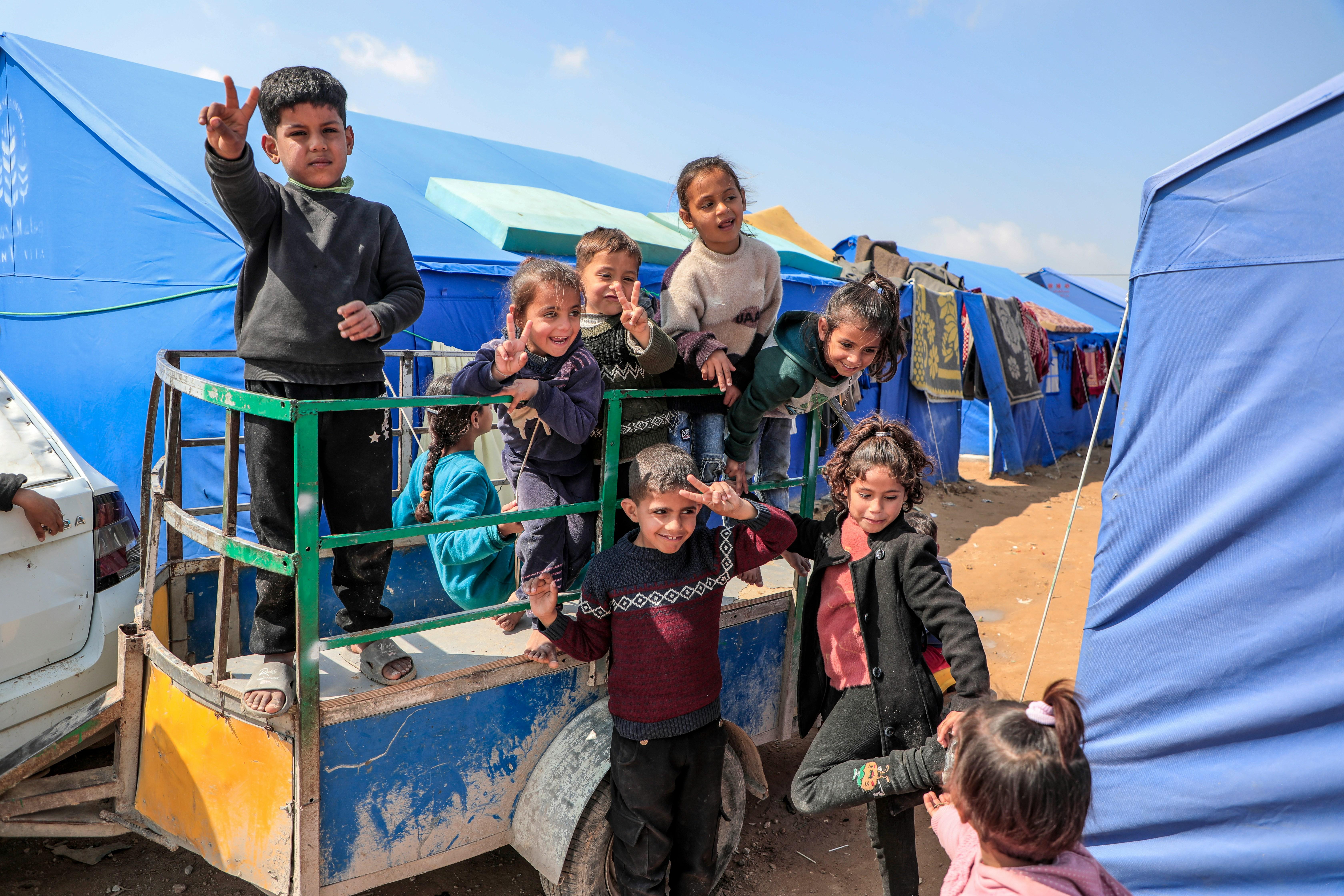 Children smiling at a camp in Gaza.