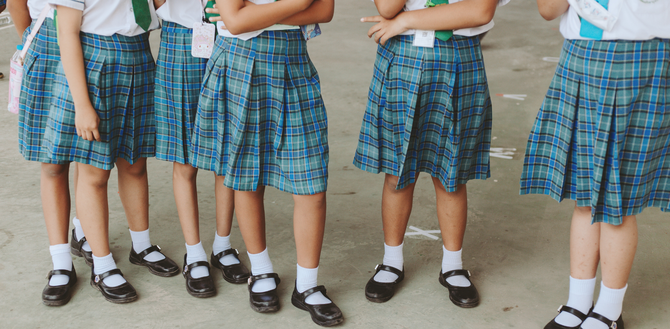 girls in school uniforms standing around