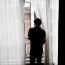 young man looking out his window