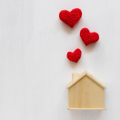 a wooden house shape with hearts coming out of the top