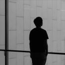 silhouette of a person standing in front of a window alone