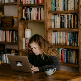young girl typing on a laptop