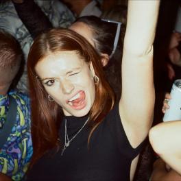 a group of people at the party with one woman looking into the camera winking