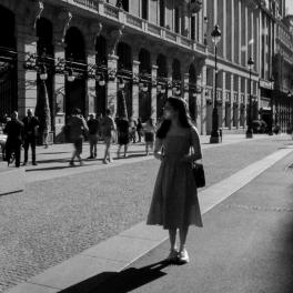 black and white photo pf a young woman walking down a city street 