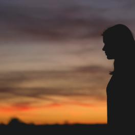 silhouette of a young woman in front of a sunset