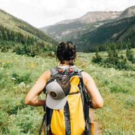 a young woman hiking through a valley