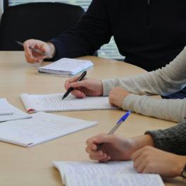 a few people sitting at a table taking notes