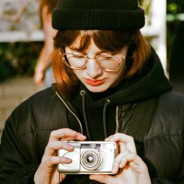 young woman holding a film camera
