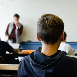 Classroom full of kids facing the teacher at the front