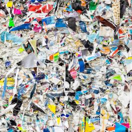 Colorful collage of remains of posters on street posters wall. Pieces of paper with steel staples.