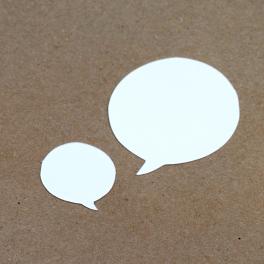 two paper speech bubbles on a plain bulletin board