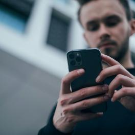 A man looking down at a smartphone. 