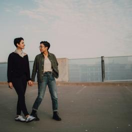 Two queer people holding hands. 