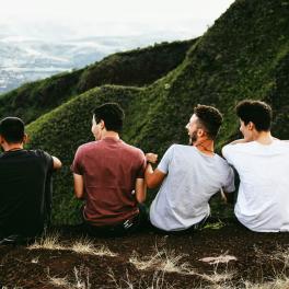 Four boys looking out over a mountain.