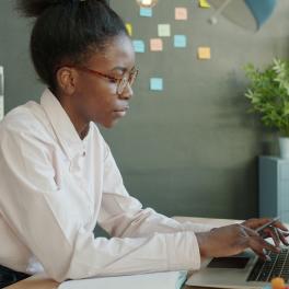 A black woman working at a computer. 